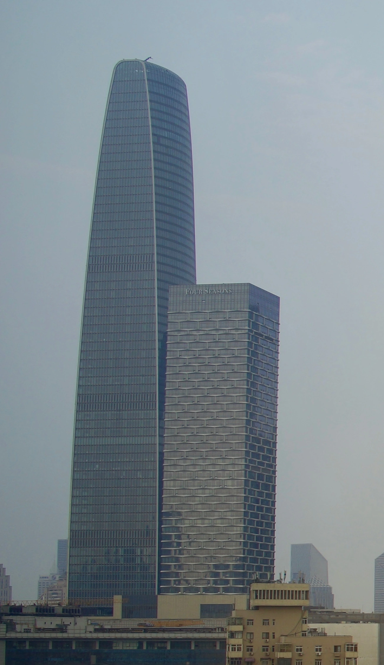 Christmas in Tianjin 2026: Dinner, Wuqing Shopping and Theatre Plans Four Seasons Hotel Tianjin is the shorter tower on the right with FOUR SEASONS rooftop lettering; the taller building on the left is the MIFC office tower, photographed on 29 June 2017